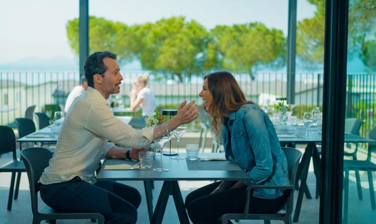 Due persone ridono insieme in un ristorante all'aperto.