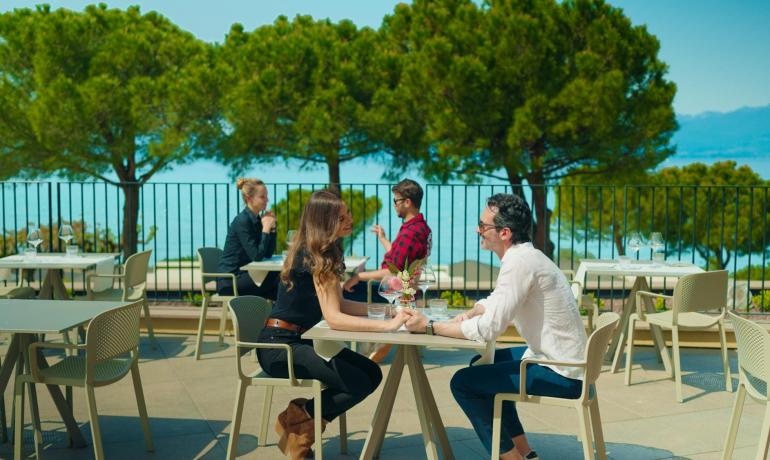 Romantic couple on terrace with sea view, sunny day.