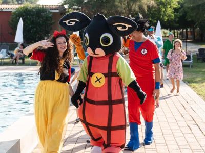 Personaggi in costume vicino alla piscina.