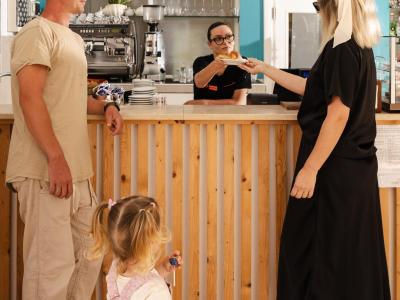 Famiglia felice al bar, ricevendo un dolce con sorrisi e calore.