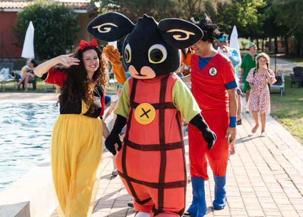 Personaggi in costume vicino alla piscina.