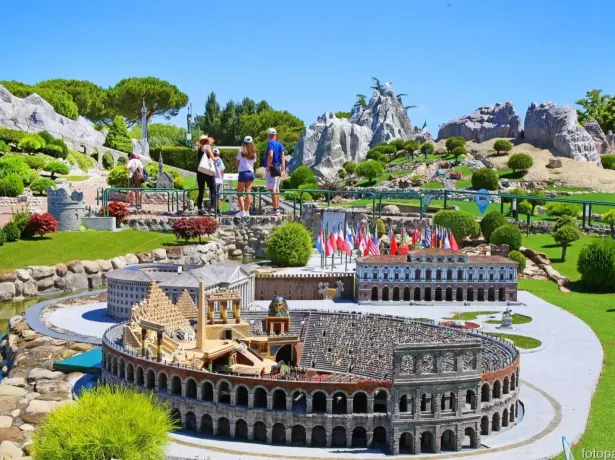 Miniaturmodelle von Denkmälern, mit Menschen, die sie in einem sonnigen Park bewundern.