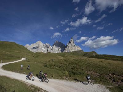 Ciclisti su sentiero montano con vista sulle Dolomiti.