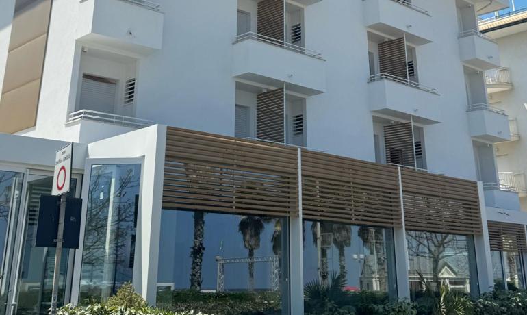 Edificio moderno e luminoso sotto un cielo azzurro, evoca serenità e pace.